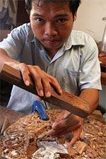Photo by: TRACEY SHELTON A land mine victim carves a wooden Apsara at the Cambodian Disabled People's Organization at Wat Than Phnom Pen